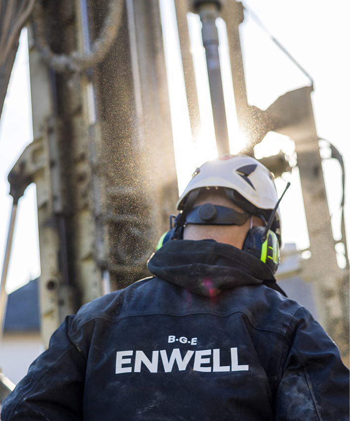 Personal från enwell med borranläggning i bakgrunden